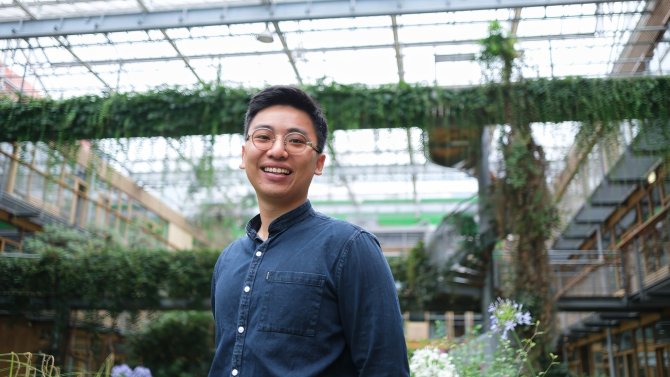 Nam stands in a greenhouse